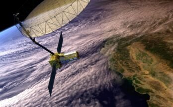 Artist's concept depicts the NASA-ISRO Synthetic Aperture Radar with a main satellite body having two solar panels and a boom attached to the large antenna reflector. The Earth below shows clouds covering the coast of California and the Pacific Ocean.