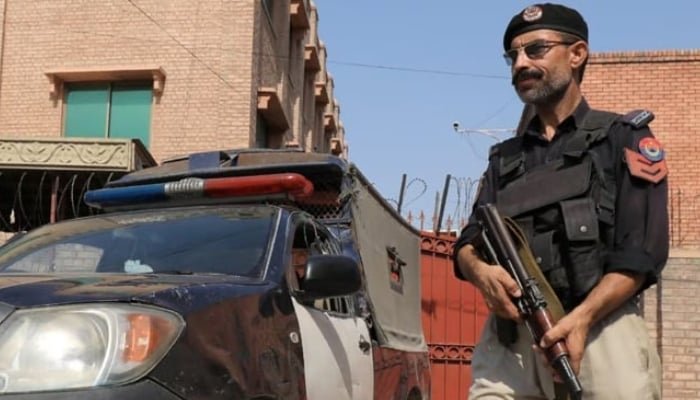 بلوچستان کا ایک پولیس افسر اپنی گاڑی کے قریب پہرہ دے رہا ہے۔ - رائٹرز/فائل