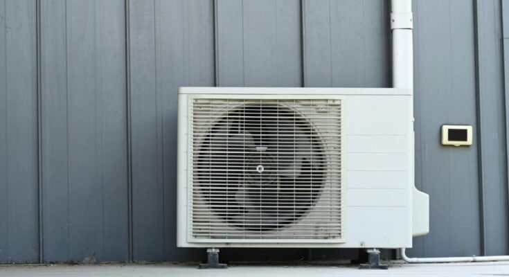 Air conditioner (AC) or heating ventilation air conditioning system (HVAC) beside house.