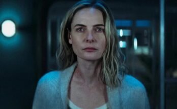 closeup of a blonde woman in white top and blue sweater