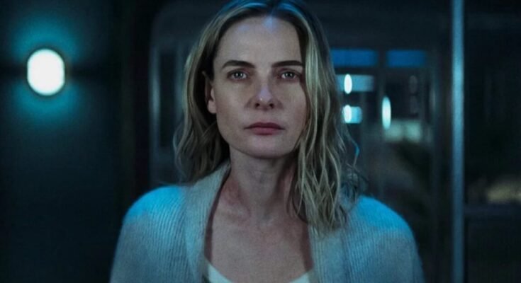 closeup of a blonde woman in white top and blue sweater