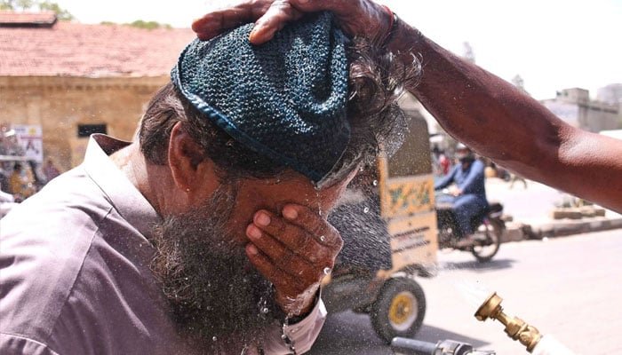 ایدھی فاؤنڈیشن کا ایک رضاکار کراچی میں شدید گرمی سے نجات کے لیے راہگیروں پر پانی کا چھڑکاؤ کر رہا ہے۔ آن لائن