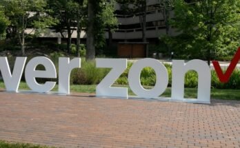 Outside a Verizon corporate building, a sculpture displays Verizon's logo with the letters V-E-R-Z-O-N and a space in the middle where the letter "I" should be.
