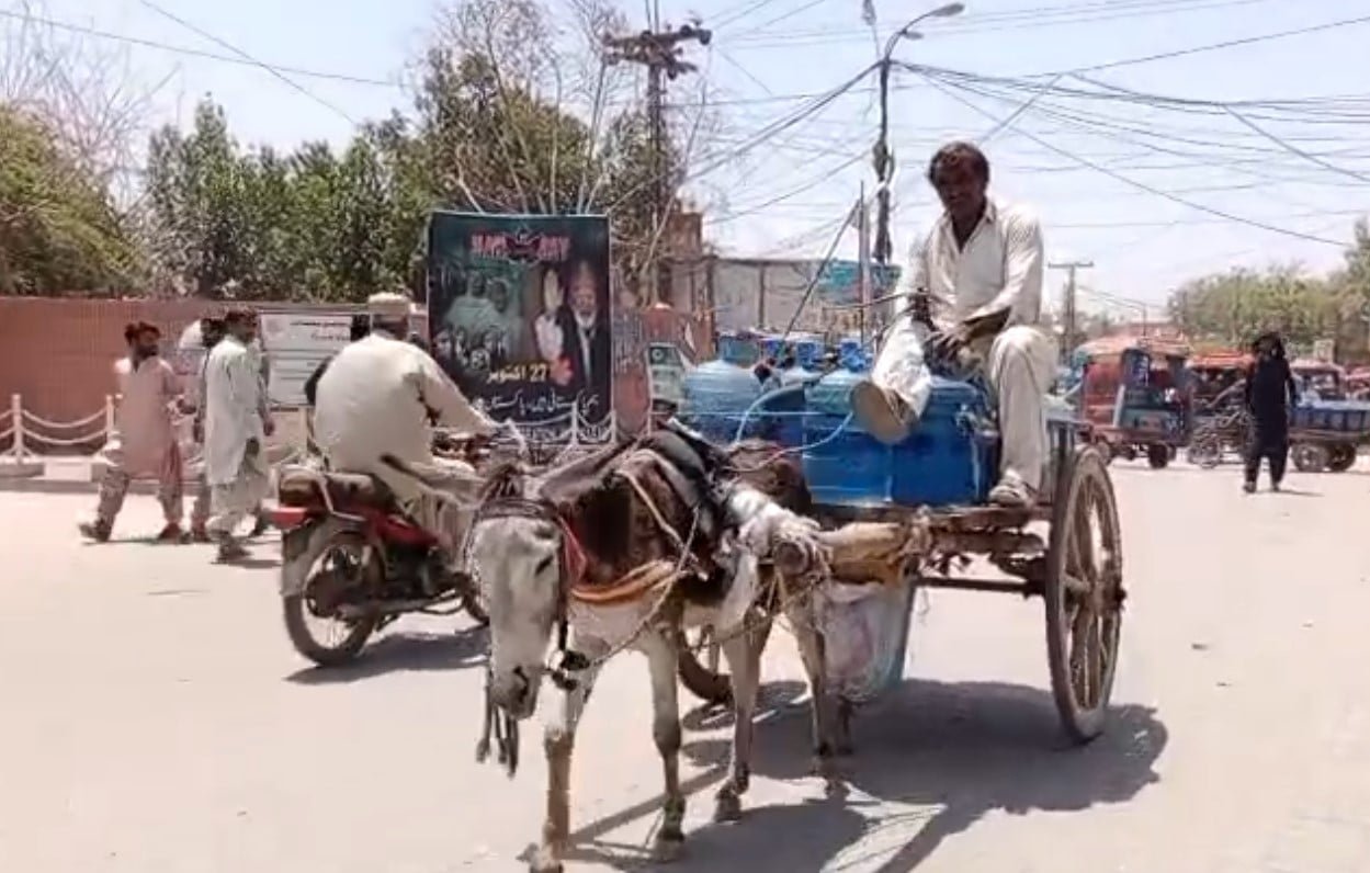 جیکب آباد میں 5 جون 2026 کو ایک مزدور گدھا گاڑی پر پانی کے کنٹینرز لے جا رہا ہے۔ - جیو نیوز