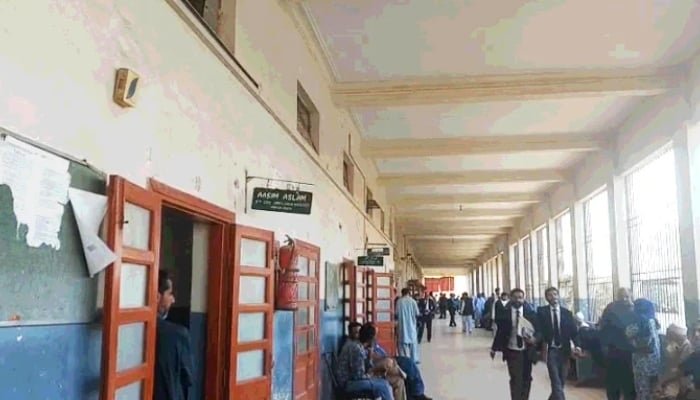 اس غیر شناخت شدہ تصویر میں لوگ کراچی کی ایک نچلی عدالت میں ایک دالان سے گزر رہے ہیں۔ - جیو نیوز/فائل